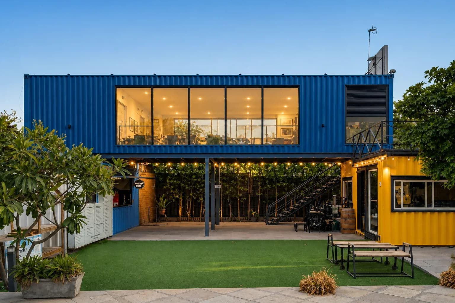 Illustrative render of a two-storey container cafe concept with a glass-fronted upper container on steel columns