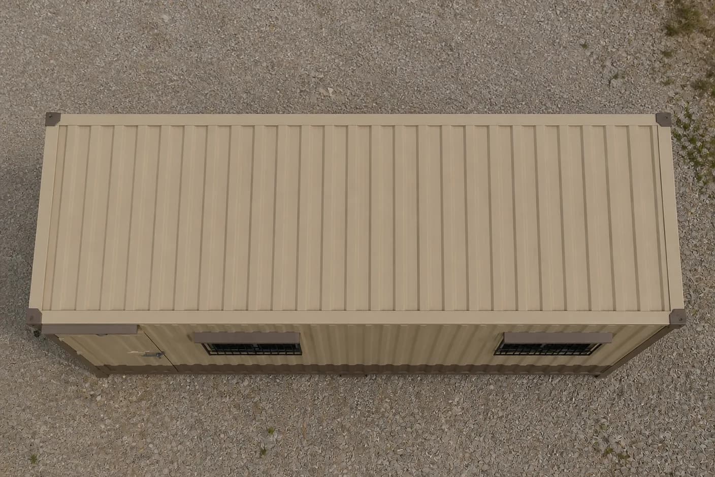 Portable cabin in Gummidipoondi — illustrative top-down view of the beige ribbed-steel cabin roof with brown corner fittings, the door and the two grilled windows, on a gravel yard