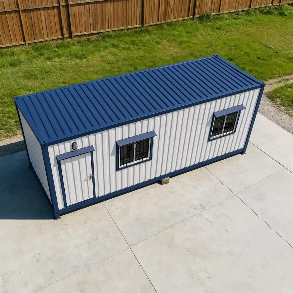 Portable cabin in Perundurai — illustrative raised view showing the cabin's navy corrugated roof, the door and grilled windows, on a concrete yard beside a lawn