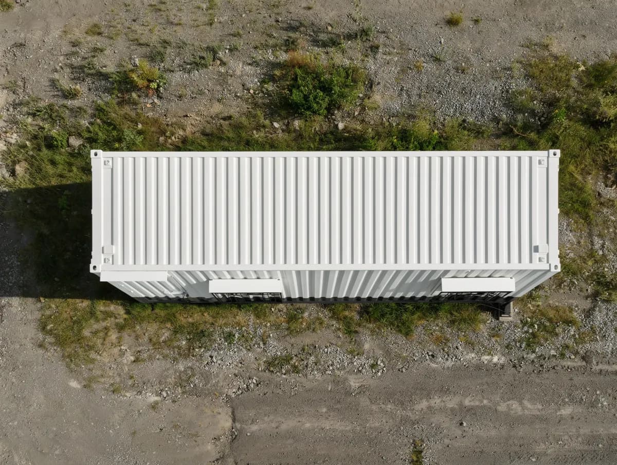 Portable cabin in Vasanthapura — illustrative aerial view of the cabin's white corrugated roof, with window hoods along one long side, on open ground