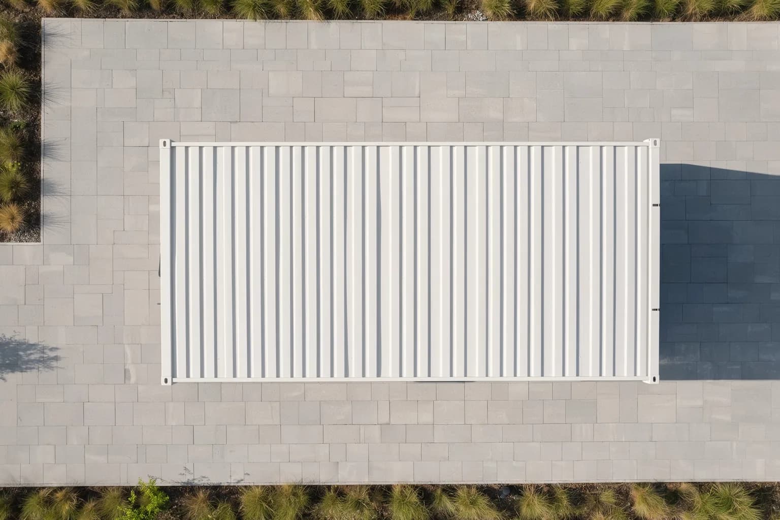 Portable cabin for Vemgal Industrial Area sites — illustrative top-down view of the white ribbed-steel cabin roof on a paved plot edged with grass