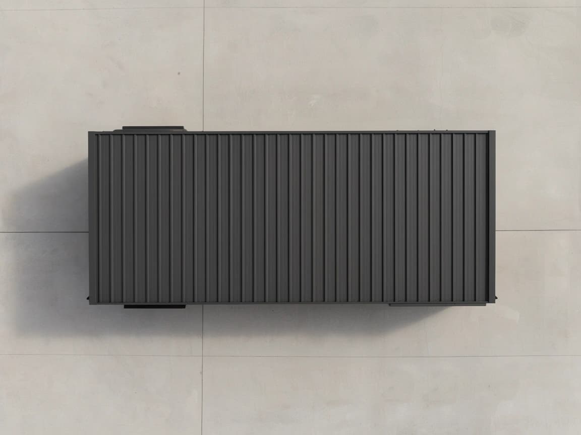 Portable container office for Thoothukudi — top-down view of the charcoal-grey profiled-sheet roof of the portable office, with the fittings along its long edges visible, placed on a light concrete yard