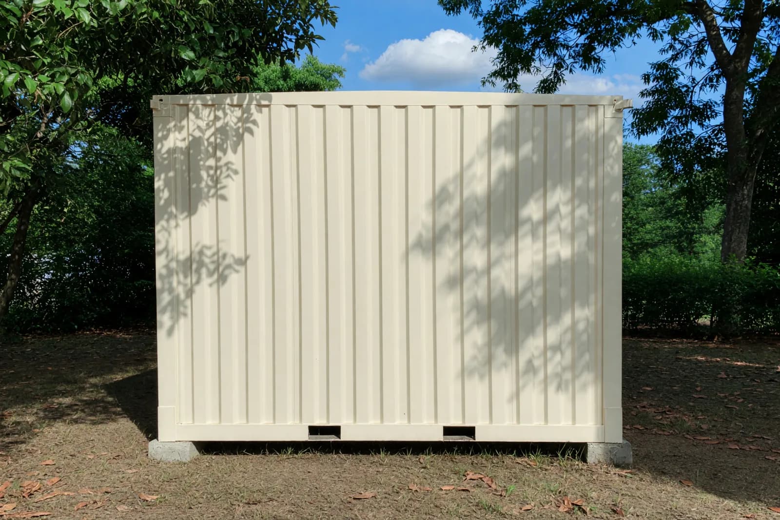 Illustrative render of the portable shop cabin's solid rear wall, standing on corner blocks